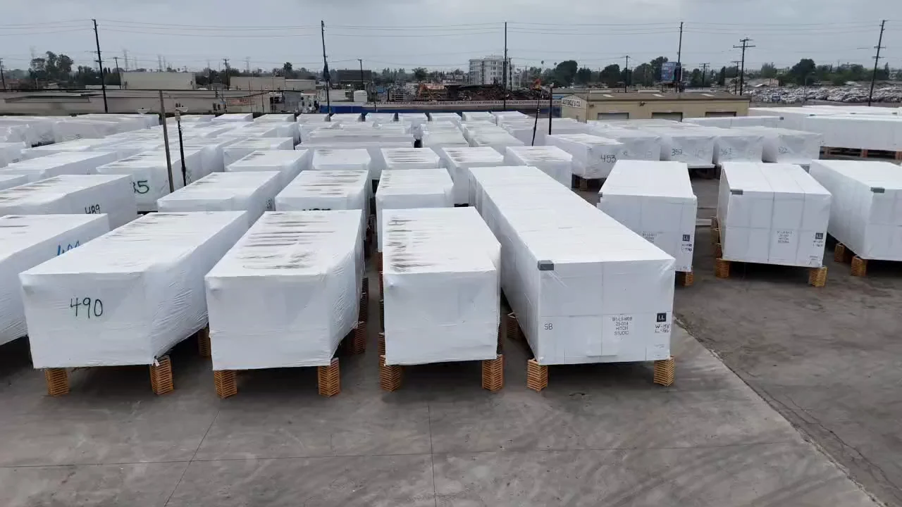 Numbered, white-wrapped modular sections staged on cribbing in the yard, ready to move